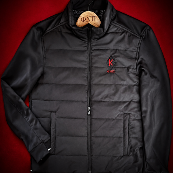 Custom embroidered black hybrid quilted performance jacket with crimson diamond insignia and Greek letter abbreviation on left chest, reflective cuff and hem details, multi-pocket system.