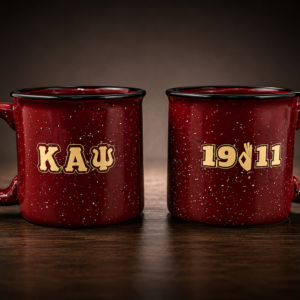 Pair of deep crimson speckled ceramic campfire mugs with black rim band, large C-handle, and personalized cream collegiate lettering showing organization name and founding year.
