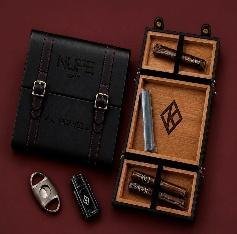 Black leather travel humidor with gold buckles and red stitching, open to show cedar tray, cutter, lighter and pen