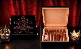 Black 1911-engraved humidor open to show cedar interior filled with cigars, against a red backdrop