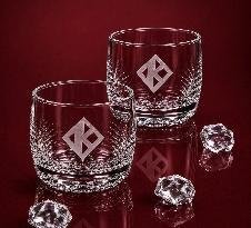 Cut-crystal glasses etched with the floating-K diamond insignia on a red backdrop