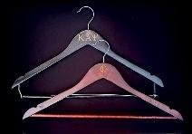 Two engraved wood clothes hangers in dark mahogany and black finishes with Greek lettering