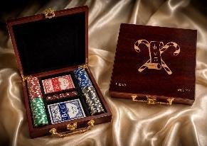 Rosewood box with an engraved lid open to show two card decks, poker chips and dice on satin