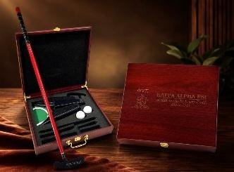 Rosewood box open to show a putter, golf balls and tees, with an engraved closed lid alongside