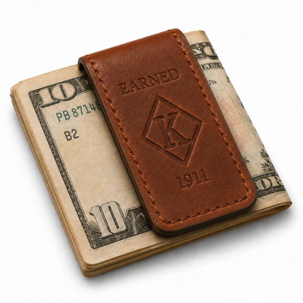 Earned brown leather money clip holding folded currency